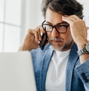 Stressed businessman having call at work