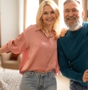 Happy senior couple holding opened door
