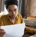 woman in eyeglasses looking through paper