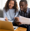 happy african american couple reviewing bills