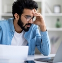 Stressed man working on laptop.