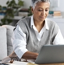 Businesswoman diligently operating her laptop.