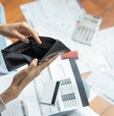 woman staring empty wallet with bills