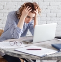 frustrated woman holding head with laptop