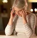 stressed senior woman filling tax form
