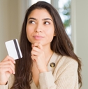woman holding card while thinking