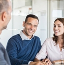 A businessman sitting at a table with two customers.