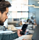 male broker using smartphone and laptop