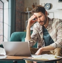 male accountant stressed at tax forms