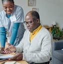 young caregiver helping senior man