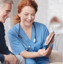 nurse showing tablet to senior patient