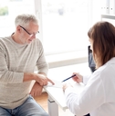 senior man with doctor discussing prescription