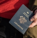 woman wearing coat holding passport