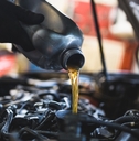 mechanic pouring oil into car engine