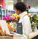 african american female florist inspecting flowers