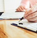 man signing documents at office