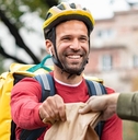 A delivery man handing off a food order.