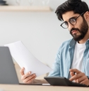 man calculating bills at kitchen table