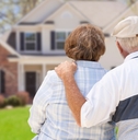 retired couple sitting outside new house