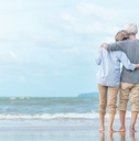 senior couple enjoying beachside waves