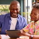 senior couple reviewing bills using tablet