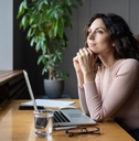 woman thinking about goals at desk