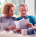 senior couple reviewing bills on couch