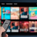 man streaming tv programs using remote