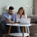 Young Couple reviewing bills at home 