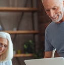 senior couple sorting finances using laptop
