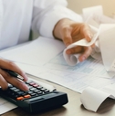man calculating expenses using calculator