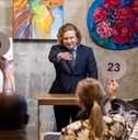 mature male auctioneer pointing at people