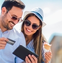Smiling couple using a credit card on a tablet