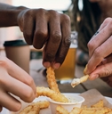 multi ethnic friends eating french fries