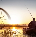 man fishing at sunset in lake