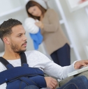 man with arm injury using laptop