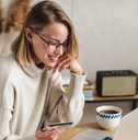 Smiling woman holding a credit card and looking at a computer