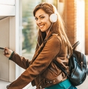 Woman wearing headphones and using an ATM