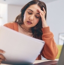 stressed woman reviewing bills at home