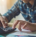 man reviewing bills using calculator
