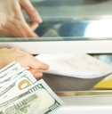 Bank teller handing his client cash