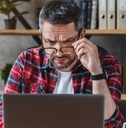confused businessman looking at laptop screen