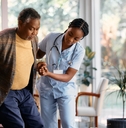 nurse assisting senior man on wheelchair