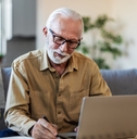 senior man reviewing insurance papers online