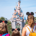 A family stands in front of the Princess Castle at Disney. 