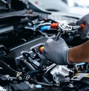 Mechanic repairing engine at garage workshop