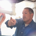 male plumber talking to house owner