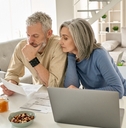 worried senior couple checking documents