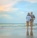 senior couple walking on the beach