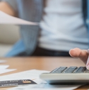 stressed woman reviewing debt using calculator